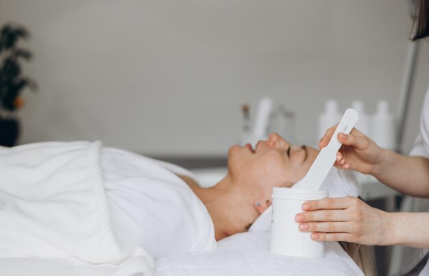 Mujer con máscara en la cara en un salón de belleza de spa foto de alta calidad