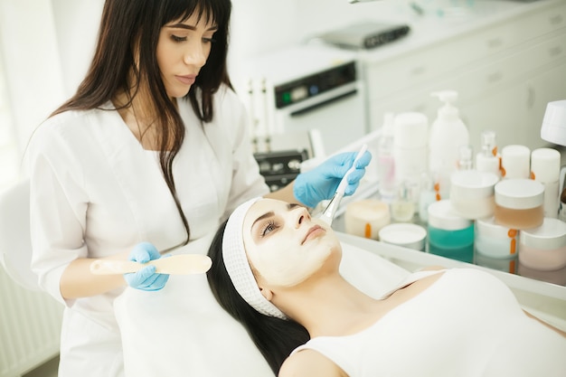 Mujer con máscara facial en salón de belleza