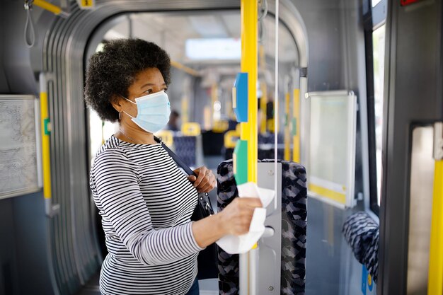 Mujer con máscara facial viajando en tranvía durante el brote de Covid-19