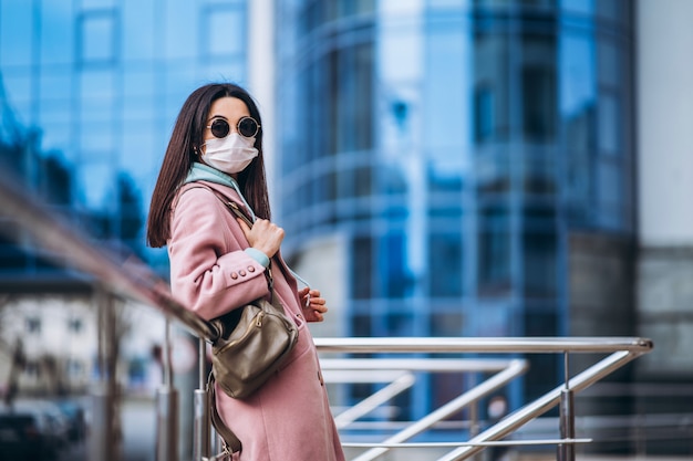 Mujer en máscara médica al aire libre en la ciudad vacía. Protección de la salud y prevención de brotes de virus, coronavirus, COVID-19, epidemia, pandemia, enfermedades infecciosas, concepto de cuarentena.