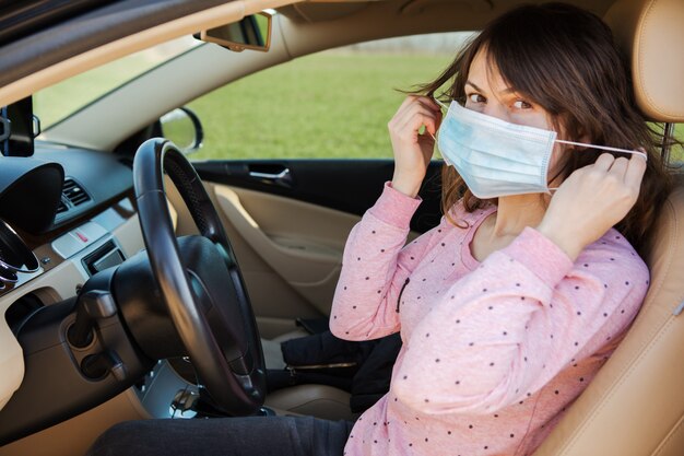 Mujer en la máscara médica en coche. coronavirus, enfermedad, infección, cuarentena, covid-19