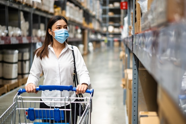 Mujer con máscara médica mirando y comprando en la tienda durante la pandemia de coronavirus