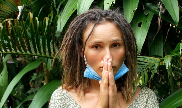 Foto mujer en una máscara médica en la naturaleza