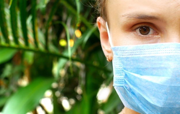 Mujer en una máscara médica en la naturaleza