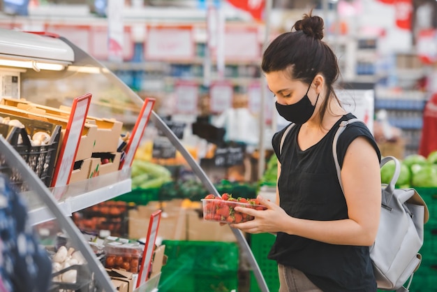 Mujer en máscara de medicina hacer compras de comestibles