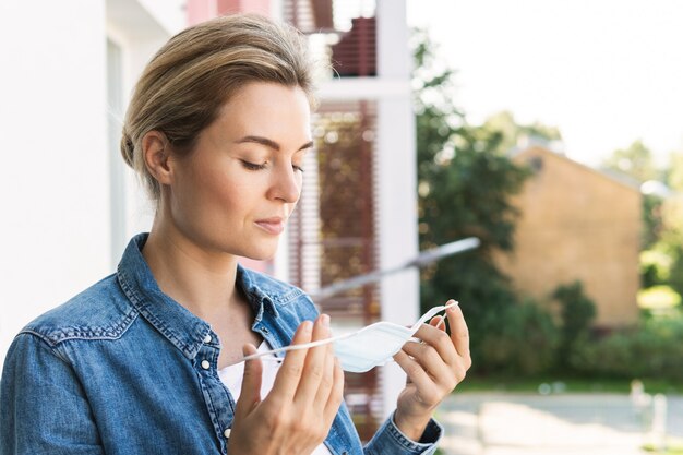 Mujer con máscara de prevención sale a tomar un respiro profundo