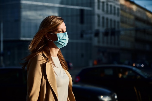 Mujer con máscara de protección en la calle de la ciudad