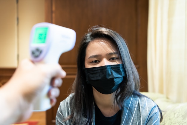 Mujer con máscara de protección contra la gripe con termocanal