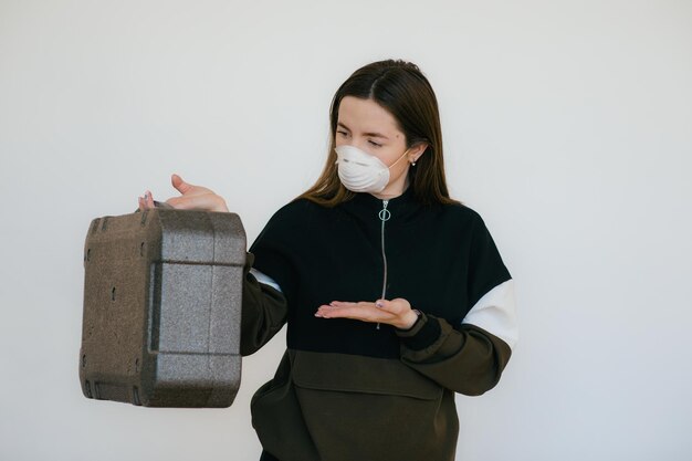 Mujer con máscara protectora con estuche gris.