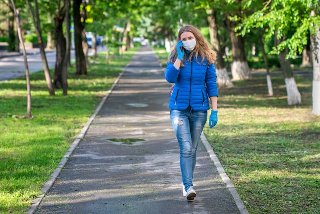 Mujer con máscara protectora y guantes caminando por la calle