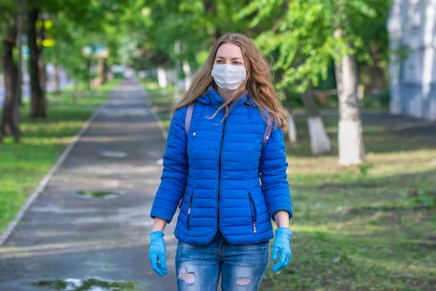 Mujer con máscara protectora y guantes caminando por la calle