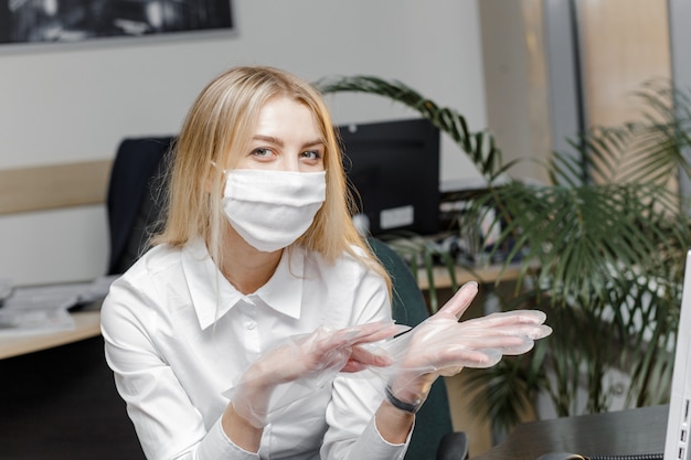 Mujer con máscara protectora y se pone guantes.