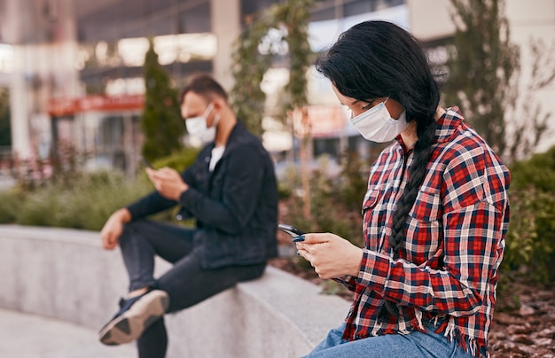 Foto mujer en máscara con smartphone en cola