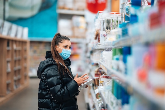 Mujer con mascarilla comprando durante la pandemia de virus