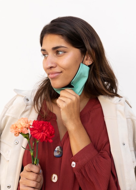 Foto mujer con mascarilla y flores