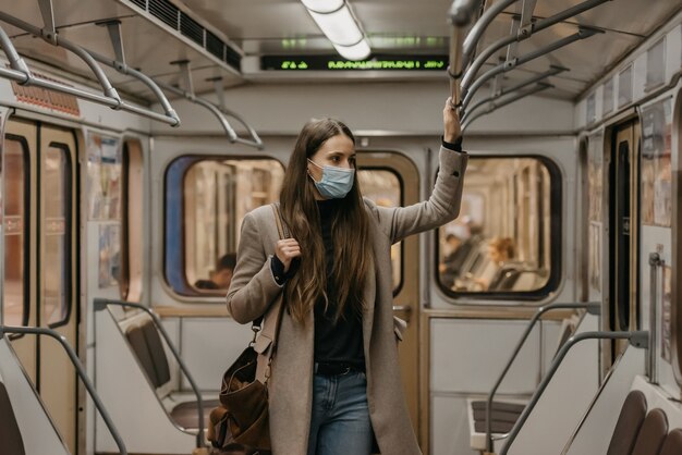 Una mujer con una mascarilla médica en la estación de metro