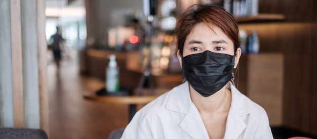 Mujer con mascarilla médica protectora en la cafetería, previene el coronavirus o la enfermedad por el virus de la corona (Covid-19). nuevo concepto normal y de salud