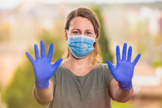 Mujer con mascarilla médica protectora y guantes quirúrgicos