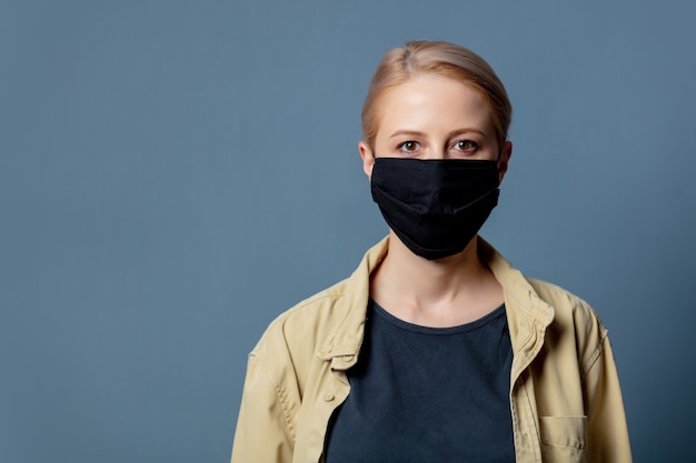 Mujer en mascarilla negra en espacio gris