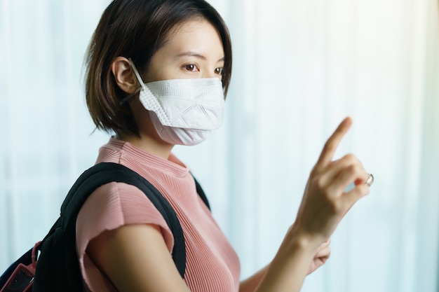 Mujer con mascarilla quirúrgica y mochila