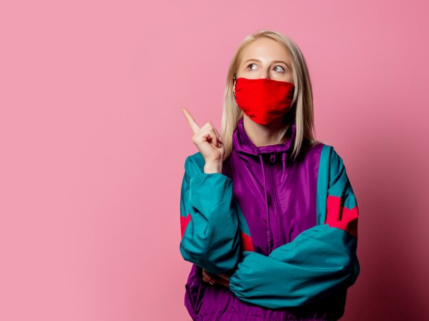 Mujer con mascarilla y ropa de los 80 en rosa