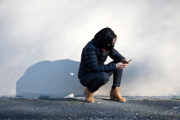 Mujer con mascarilla con smartphone en la calle