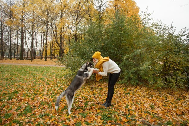 Mujer y mascota husky al aire libre Entrenamiento de perros