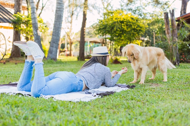 Mujer y mascota en el jardín. Labrador retriever jugando al aire libre. Mascotas y concepto al aire libre.