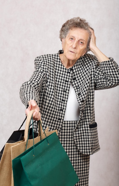 Mujer mayor entre 70 y 80 años guarda bolsas de la compra.