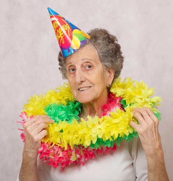 La mujer mayor de 80 años está lista para la fiesta de cumpleaños. En la traducción del cono del ruso: "Feliz cumpleaños".