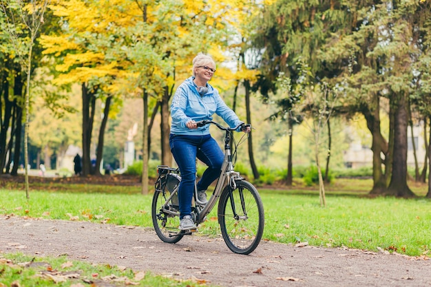 mujer mayor, ambulante, en el parque, con, un, bicicleta