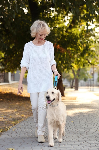 mujer mayor, ambulante, con, perro, en el parque