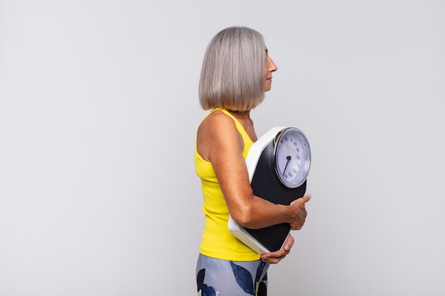 Foto mujer mayor con báscula, concepto de pérdida de peso