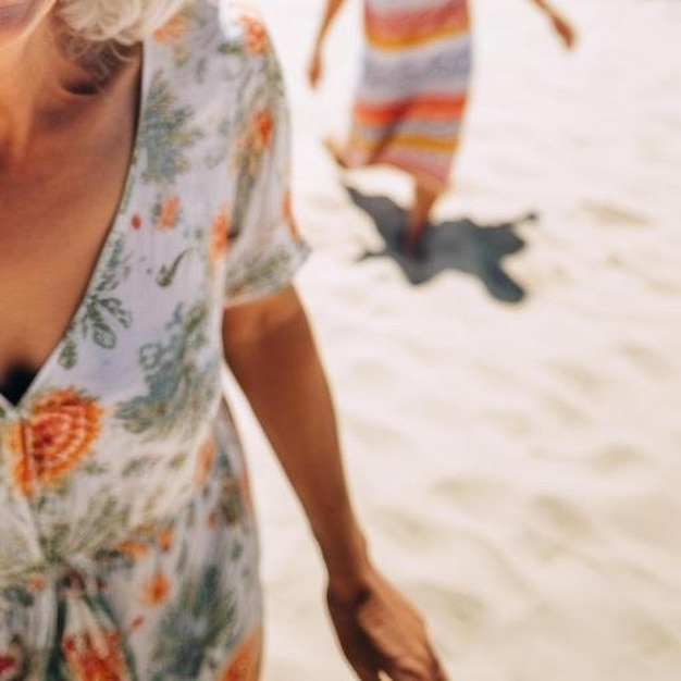 Foto mujer mayor caucásica feliz divirtiéndose sonriendo a la cámara en la playa durante las vacaciones de verano