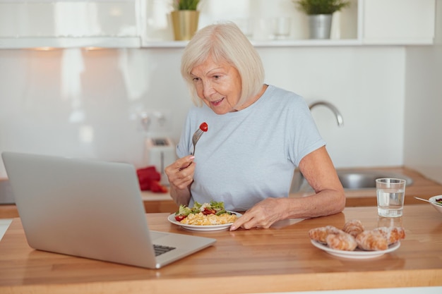 Mujer mayor concentrada desayunando en casa