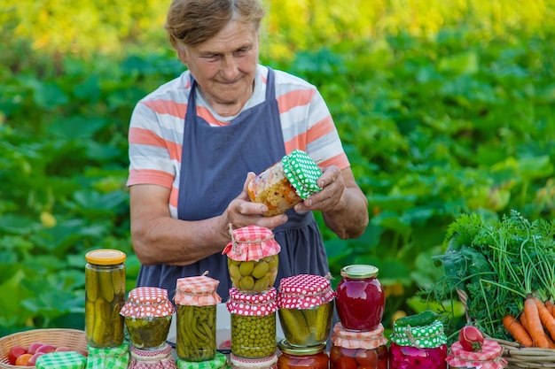 Mujer mayor conservando verduras en frascos Enfoque selectivo
