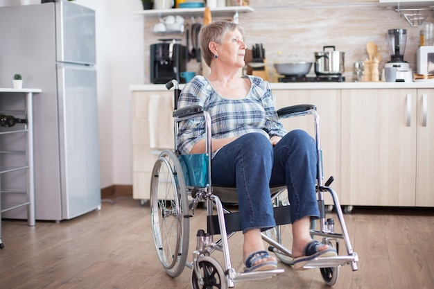 Mujer mayor discapacitada deprimida en silla de ruedas por lesión en la pierna. Pensionista anciano discapacitado en rehabilitación, parálisis y discapacidad por inválido lleno de dolor, preocupación y cara triste. Período de jubilación para ol