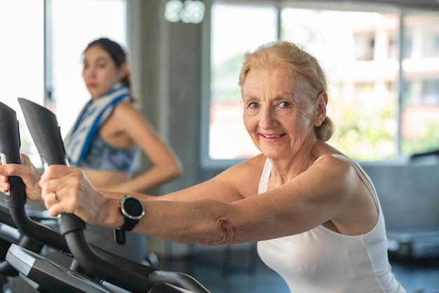 Mujer mayor ejercicio bicicleta de spinning en el gimnasio. concepto de estilo de vida saludable para ancianos.