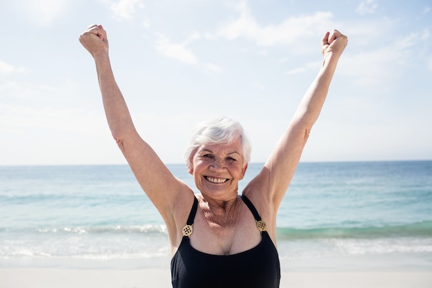 Mujer mayor emocionada de pie en la playa