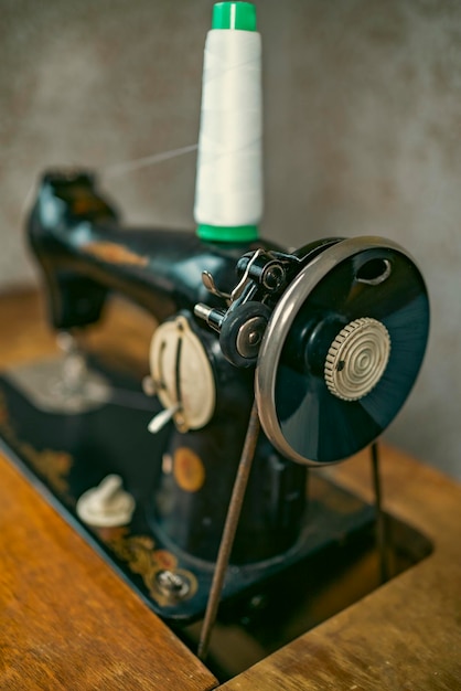 Mujer mayor en espectáculos usa máquina de coser manos arrugadas de la vieja costurera mujer mayor Máquina de coser antigua Máquina de coser manual de estilo retro clásico lista para trabajos de costura