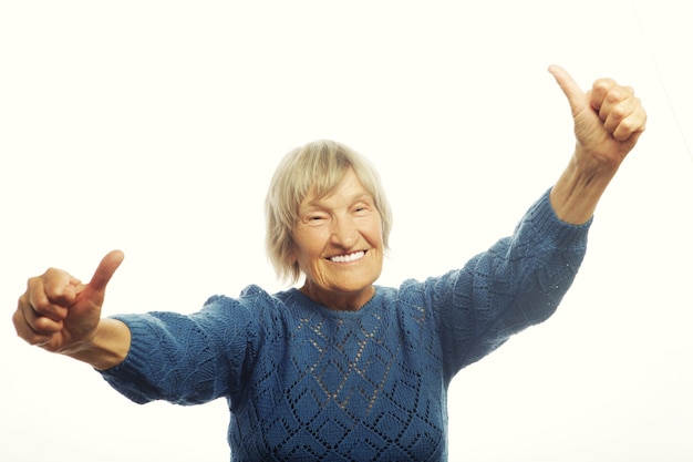 Foto mujer mayor feliz dando dos pulgares para arriba en señal de aprobación. aislado en blanco.