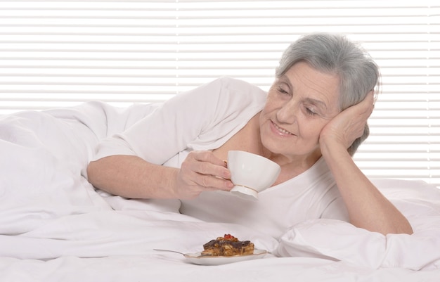 Mujer mayor feliz descansando en un dormitorio