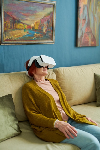 Mujer mayor con gafas vr relajándose en casa