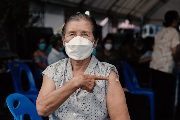 la mujer mayor ha ido a vacunar coronavirus covid apuntando hombro con vendaje