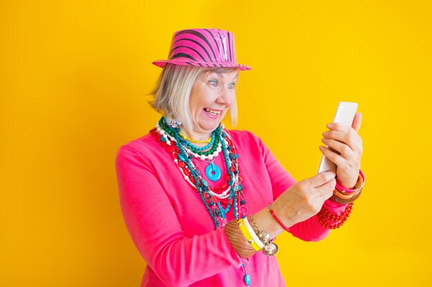 Foto mujer mayor hablando por teléfono inteligente en conceptos de ropa elegante sobre personas mayores