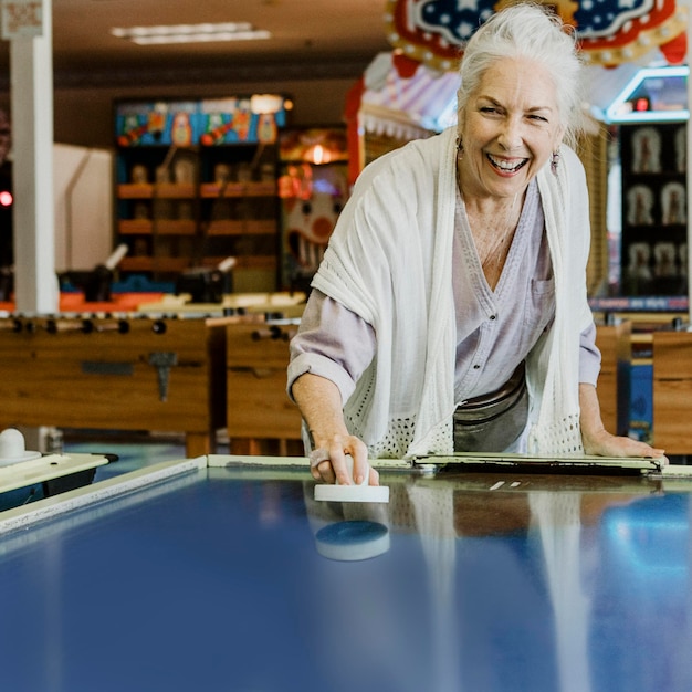 Mujer mayor, juego, air hockey