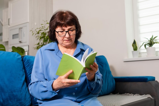 mujer mayor, lectura, sentado, en, sofá azul