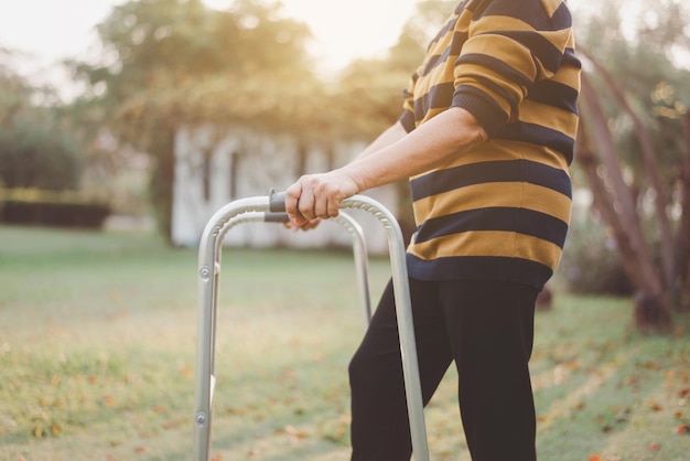 Mujer mayor manos sosteniendo andador tratando de caminar en la naturaleza Concepto de fisioterapia