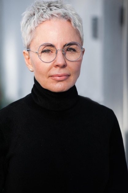 Mujer mayor de moda con cabello gris y anteojos Look casual