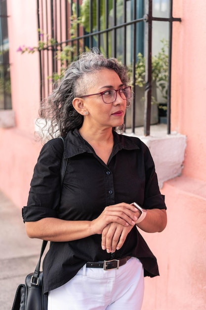 Mujer mayor moderna caminando por la calle